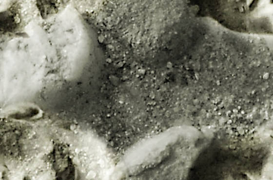 Cailloux en gros plan incrustrés dans le sol et moulage de têtes humaines, alignées en long et en large, datant de l'ère coloniale.